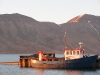 Ein alter Kutter liegt im stillen Fjordwasser